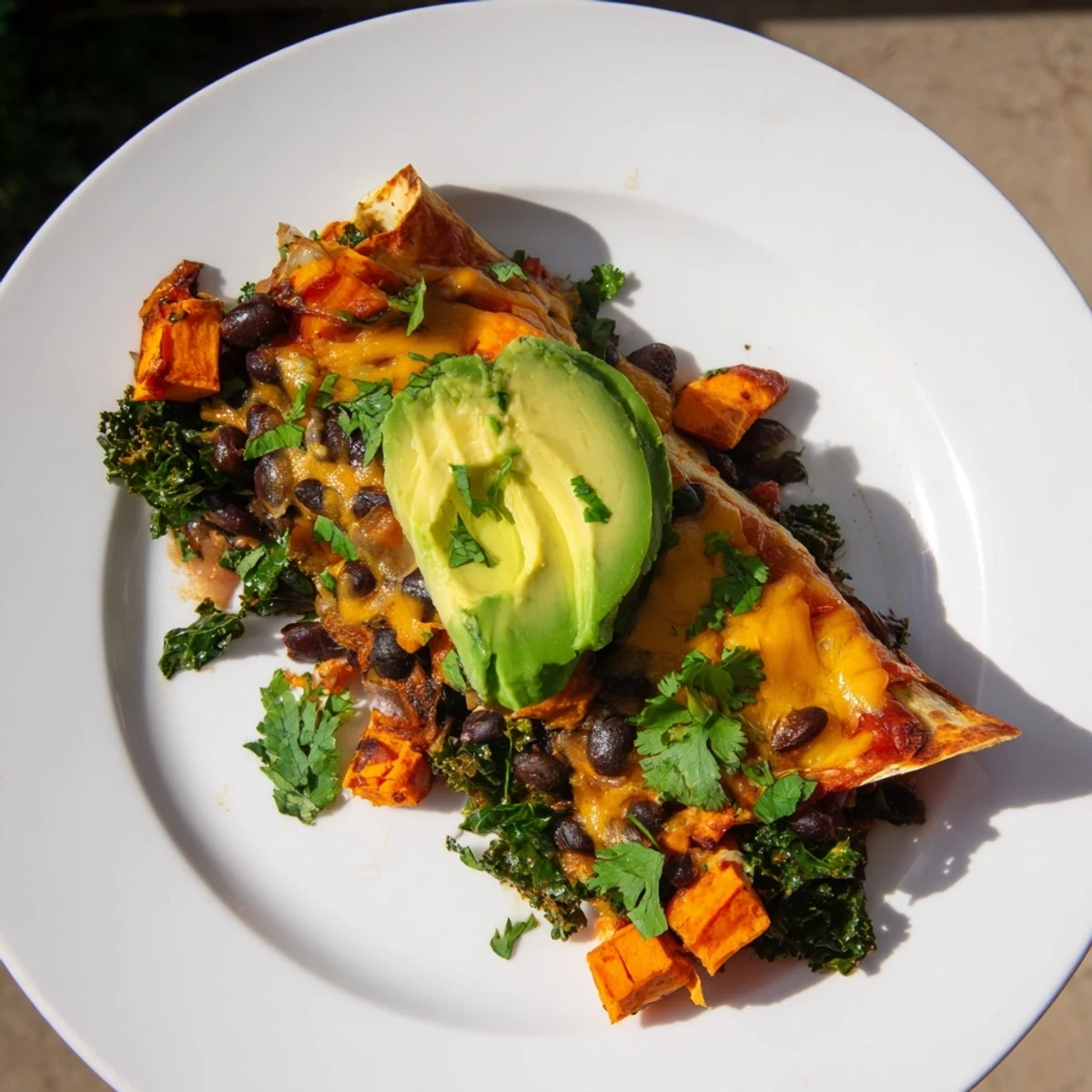 One-Pan Sweet Potato, Black Bean & Kale Enchiladas, baked with melted cheese, offer a colorful vegetarian meal.