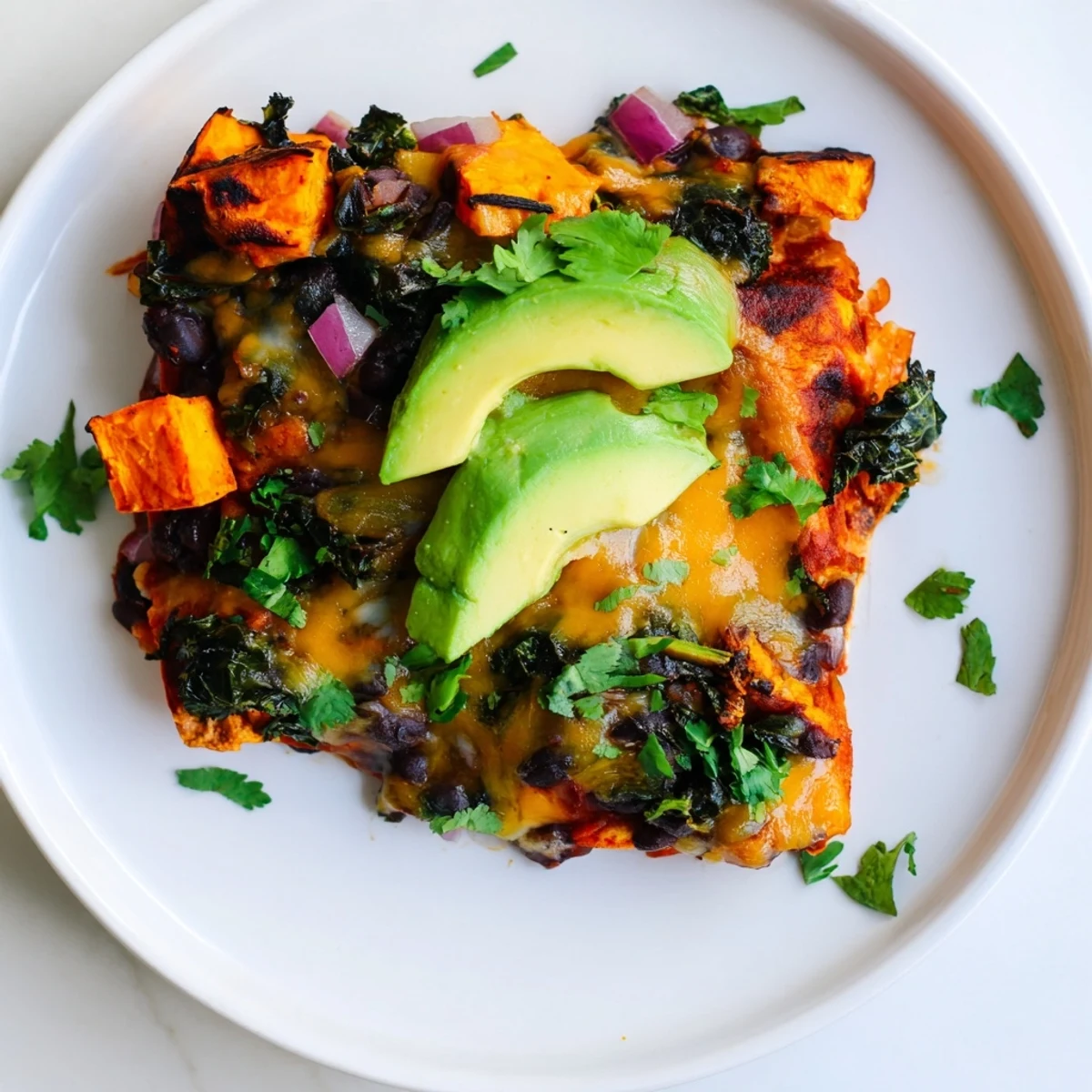 Golden, bubbly One-Pan Sweet Potato, Black Bean & Kale Enchiladas, filled with roasted vegetables, are ready to serve.