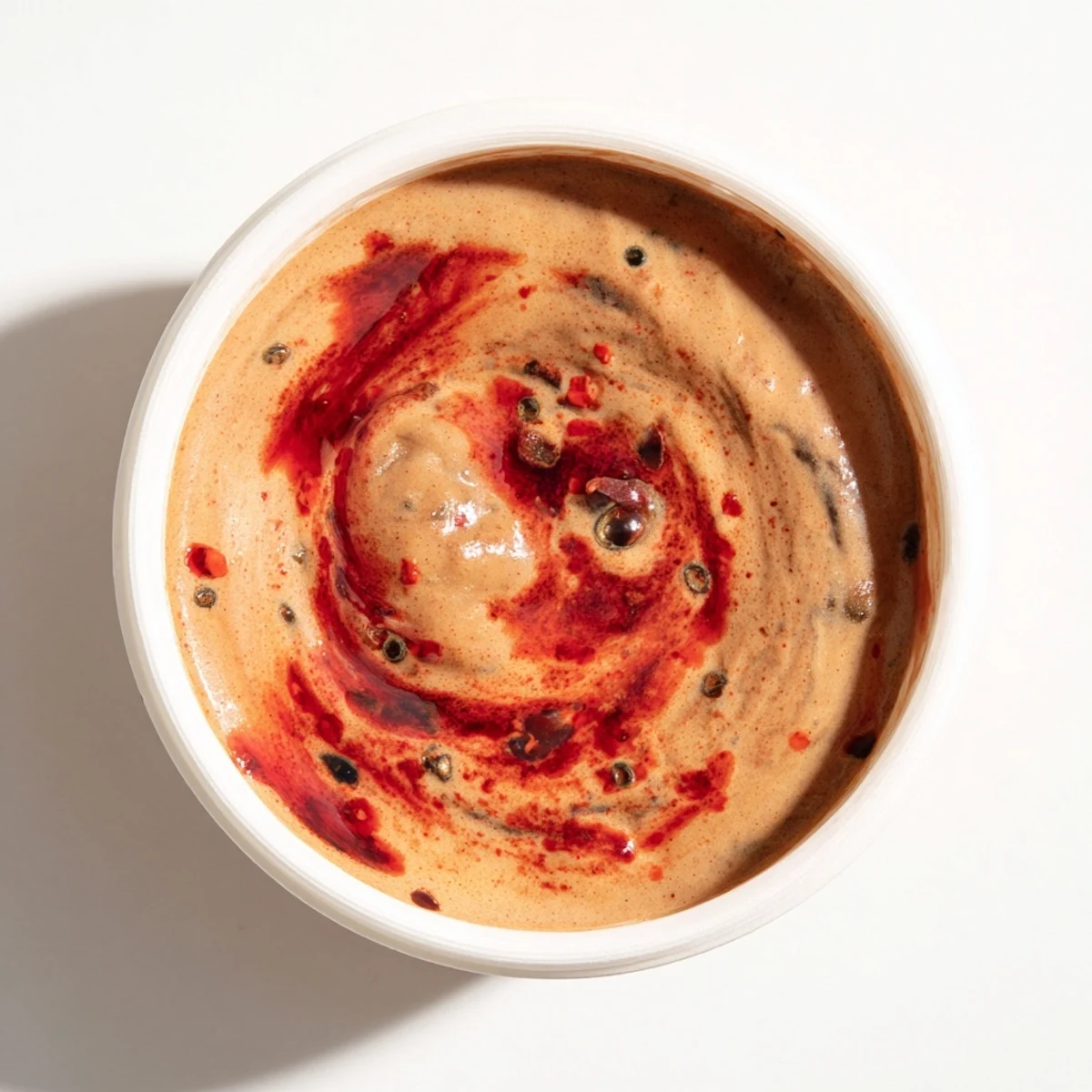 Creamy Spicy Black Bean Dip, vibrant red from salsa, ready to scoop with chips at a party.