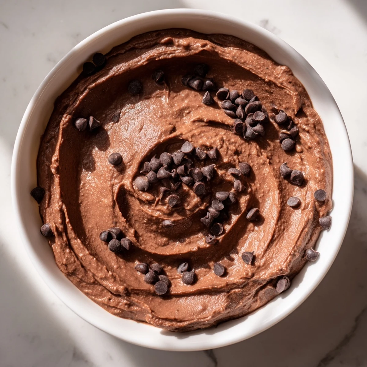 Smooth and creamy chocolate hummus, perfect for dipping apple slices, ready to savor.