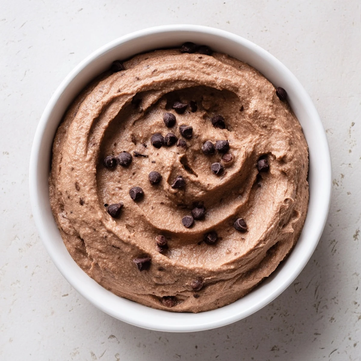 A close-up of thick, homemade chocolate hummus, ideal with fresh fruit for a sweet treat.