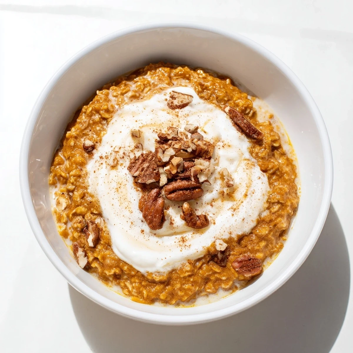 A close-up of creamy Pumpkin Spice Latte Oats drizzled with maple syrup, smelling of fresh spices.