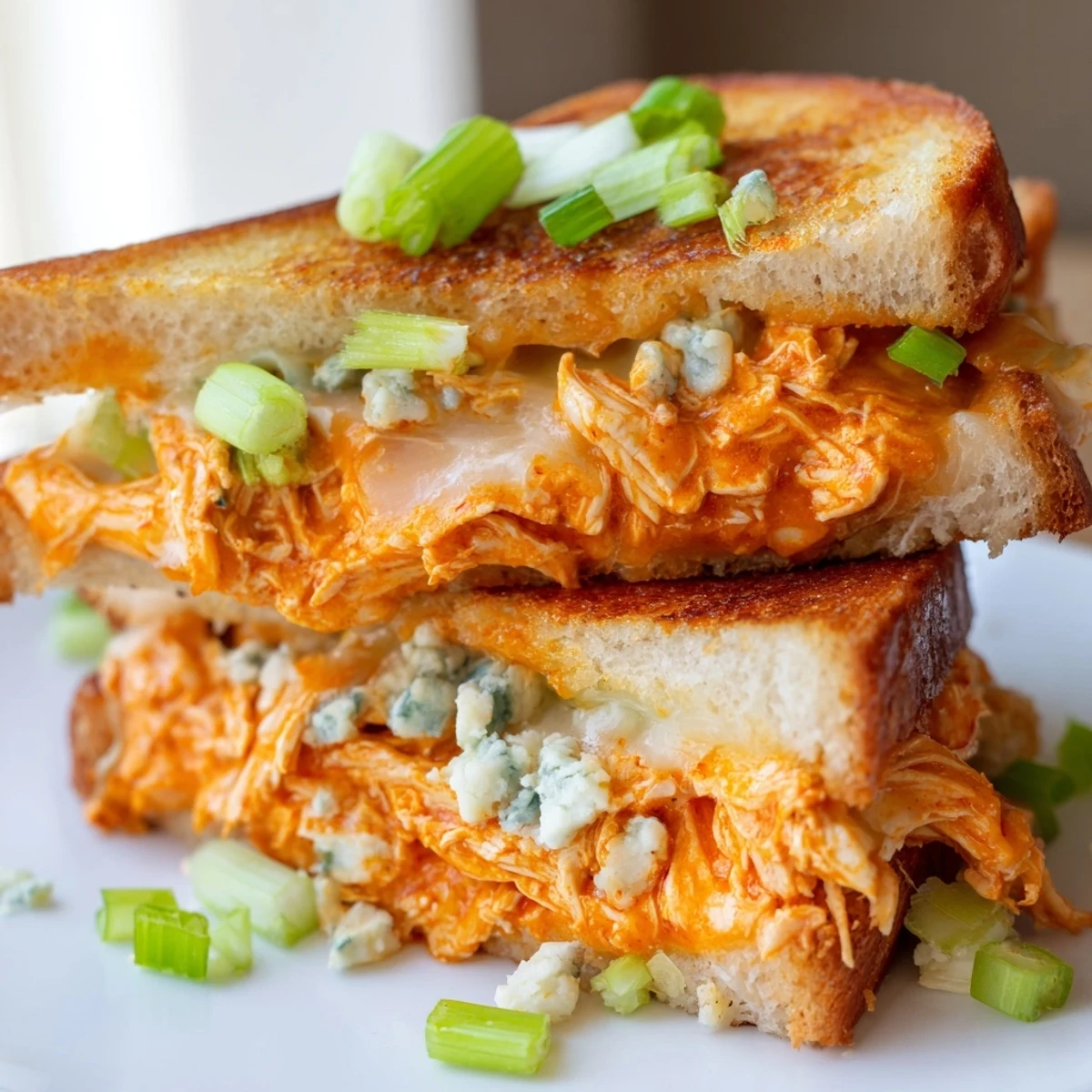 Crispy sourdough cradling savory Buffalo Chicken Grilled Cheese, featuring melted cheese and spicy chicken filling.
