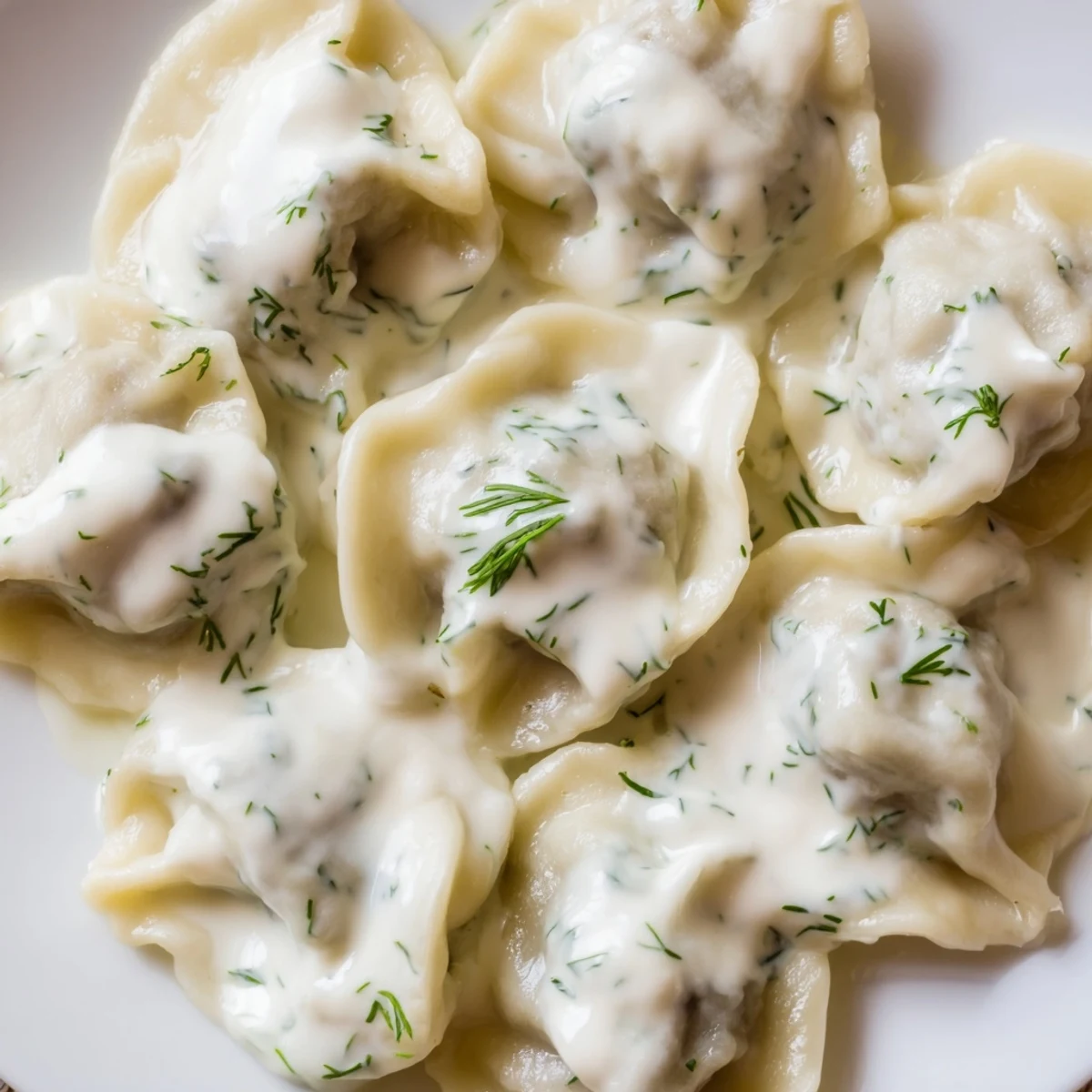 Close-up of golden-brown Russian pelmeni, perfectly cooked and served with creamy sour cream sauce.