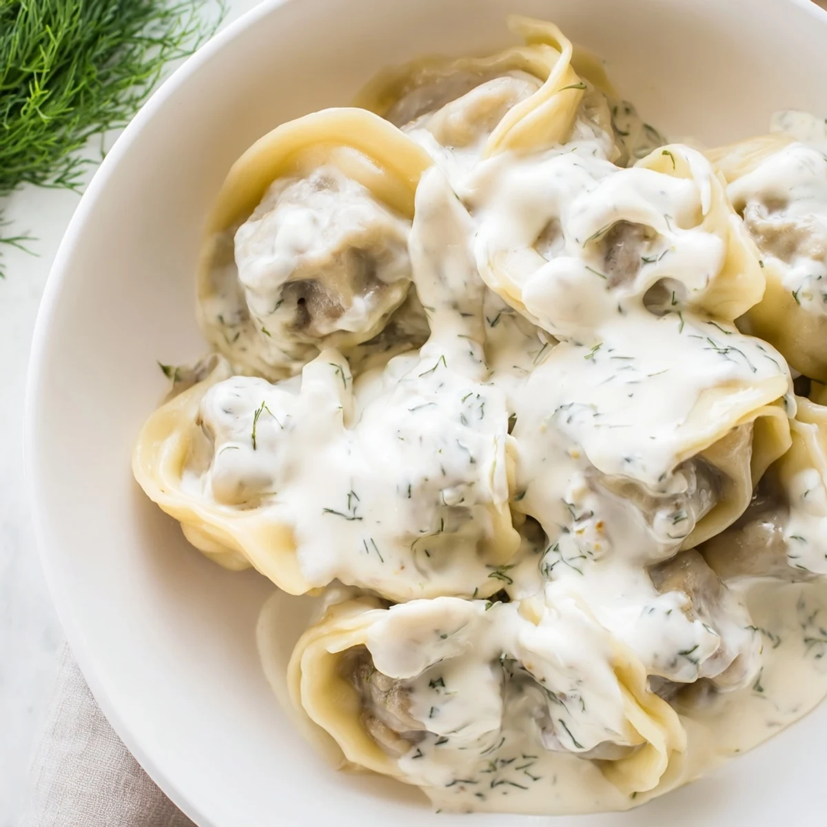 Steaming hot Russian pelmeni, tender meat-filled dumplings, ready to be enjoyed with sour cream.