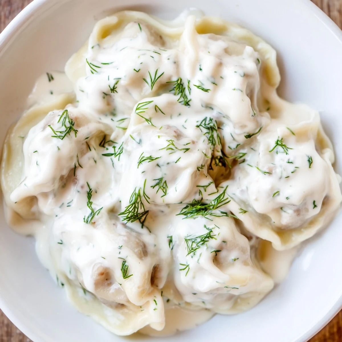 A delicious bowl of Russian pelmeni, bite-sized dumplings, featuring a savory meat filling, ready to eat.
