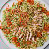 Bright serving of Protein Cucumber Salad showing sliced chicken atop fresh spiralized cucumber in a bowl.