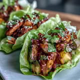 Savory teriyaki chicken and sweet pineapple served in crunchy lettuce cups with colorful vegetables and fresh herbs.  