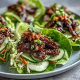 Juicy Korean BBQ beef wraps bursting with crisp lettuce, spicy kimchi, and fresh veggies.