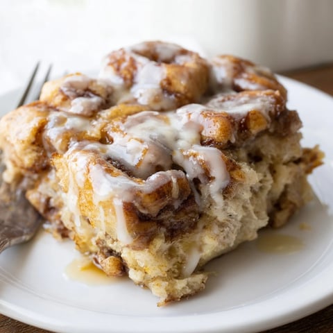 Warm Baked Cinnamon Roll Casserole topped with sweet icing and gooey maple syrup.  