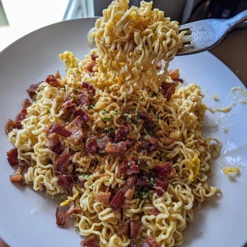 Steaming Carbonara Ramen Fusion, rich with creamy sauce and crispy bacon crumbles, ready to enjoy.