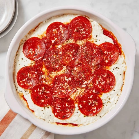 Warm, bubbling Pizza Dip, with melted cheese and crispy pepperoni, ready to scoop.