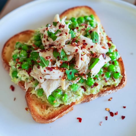 Crisp toasted sourdough topped with creamy smashed peas, shredded chicken, and a sprinkle of chili flakes.