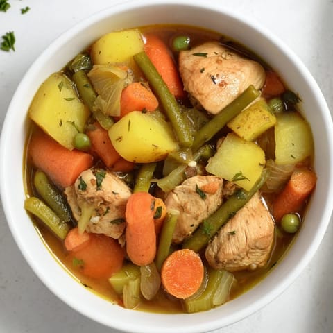 A comforting bowl of Hearty Chicken and Vegetable Stew garnished with fresh parsley.  