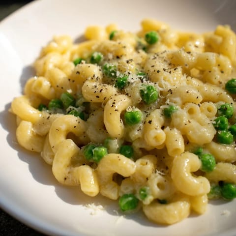 Golden, cheesy Macaroni & Peas cooked to perfection, showcasing the tender peas and rich flavors.