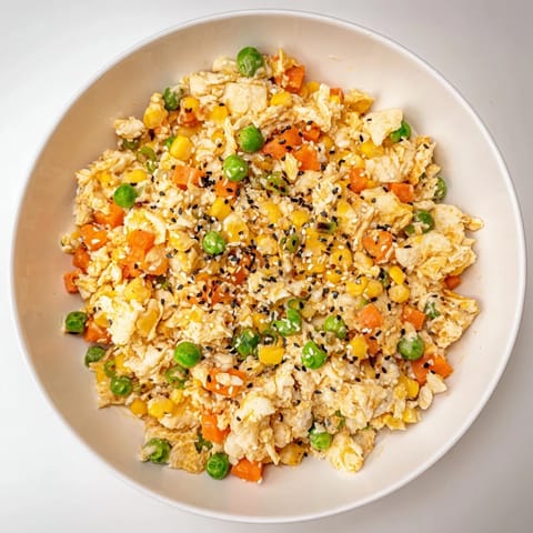 Golden-brown, flavorful Frozen Veggie Fried Rice, garnished with fresh green onions and sesame seeds, ready to eat.
