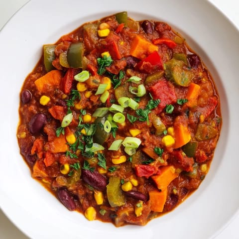 Close-up of a richly spiced veggie chili, brimming with beans and tomatoes, a perfect meal.