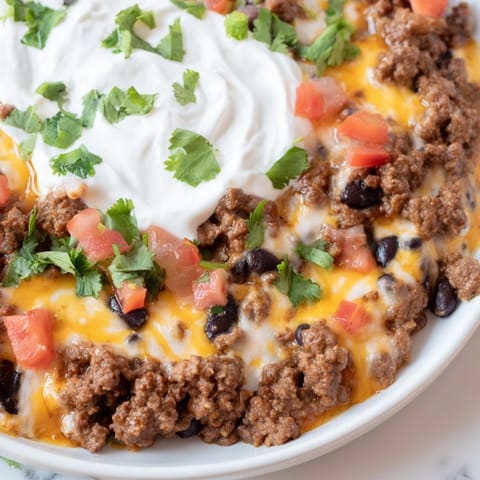 Close-up of the Slow Cooker Cream Cheese Taco Dip: rich, with melted cheese and zesty toppings.