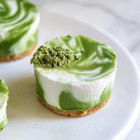 Elegant presentation of matcha swirl cheesecake cups; chilled dessert offering a flavorful fusion.