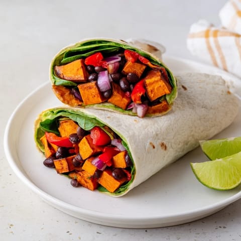 Warm, colorful Roasted Sweet Potato & Black Bean Holiday Wrap with veggies, ideal for a festive dinner.
