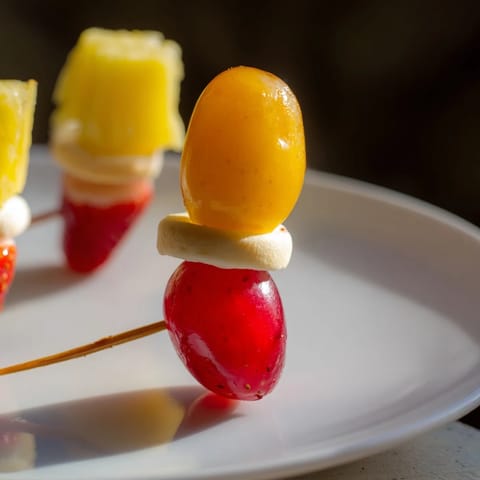 Christmas Light Fruit Skewers bursting with colorful grapes, strawberries, and pineapple, a party-perfect appetizer.