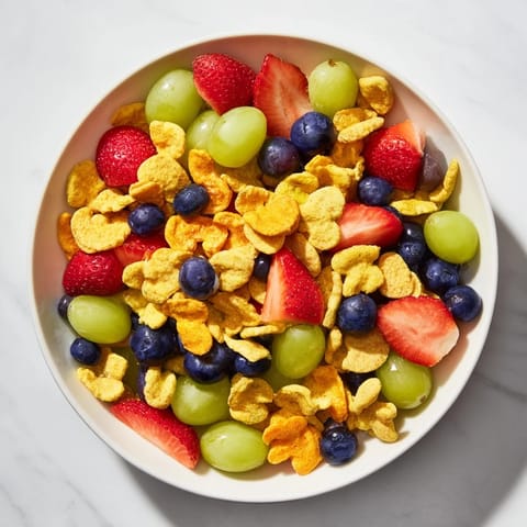 A joyful mix: rainbow Goldfish crackers cascading with berries and yogurt for dipping enjoyment.