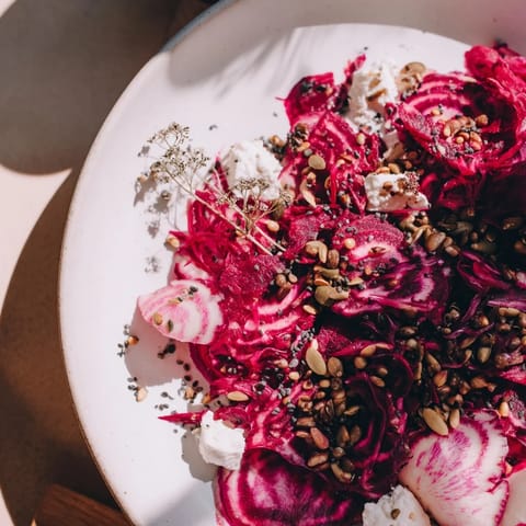 Fresh herbs and seeds sprinkled over a visually stunning Kinetic Motion Blur appetizer.
