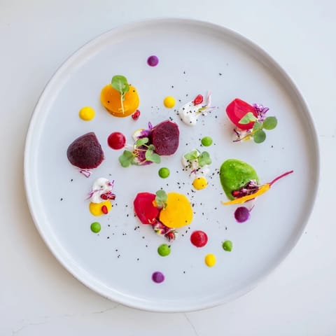 Artfully arranged The Pointillism Dot Matrix: a visually stunning plate of colorful sauces and veggies.