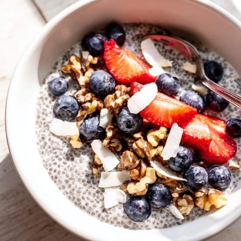 A glass jar of chia seed pudding with sliced bananas and toasted coconut, ready to enjoy as a snack.