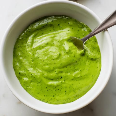 Creamy and herbaceous Green Goddess Dressing served as a dip alongside a colorful platter of crisp crudités.