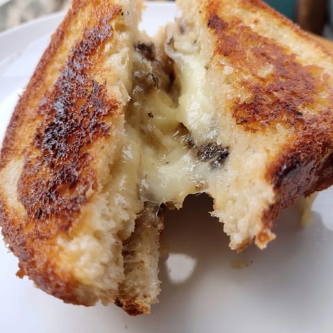 Buttery bread exterior with molten cheese center, served alongside a fresh arugula salad for balance.