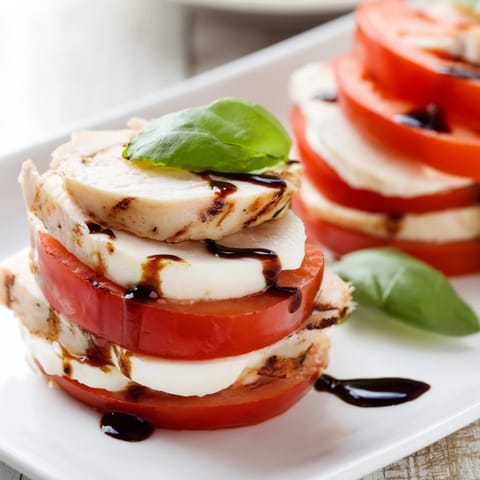 This homemade Chicken Caprese Salad features juicy tomatoes and creamy mozzarella, layered with herb grilled chicken for a fresh Italian lunch.  