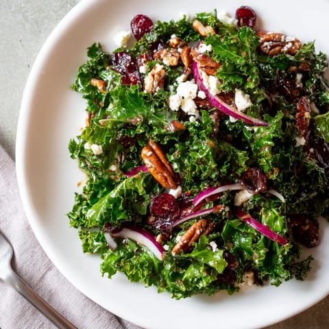 Warm Kale Salad With Maple Mustard Dressing: tender greens, sweet cranberries, crunchy nuts, served warmly.