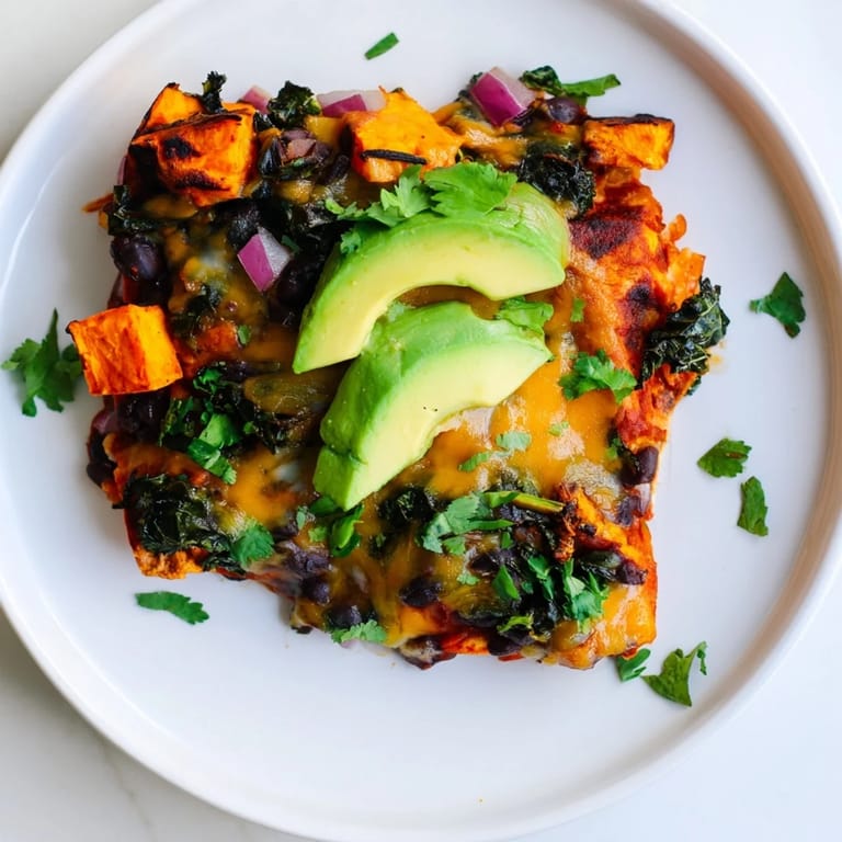 Golden, bubbly One-Pan Sweet Potato, Black Bean & Kale Enchiladas, filled with roasted vegetables, are ready to serve.