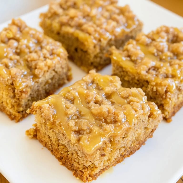 Warm and inviting display of freshly baked Lemon-Glazed Gingerbread Crumble Bars, ideal with hot tea.