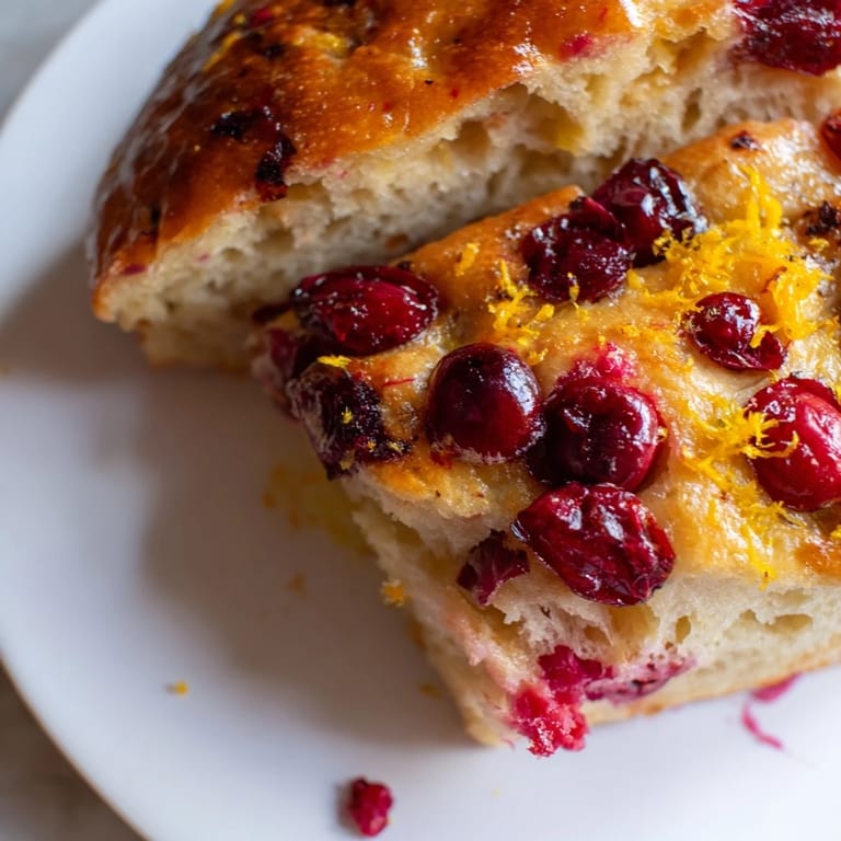 Close-up shot shows the delicious, pillowy interior of the Cranberry Orange No-Knead Focaccia, perfect for brunch.
