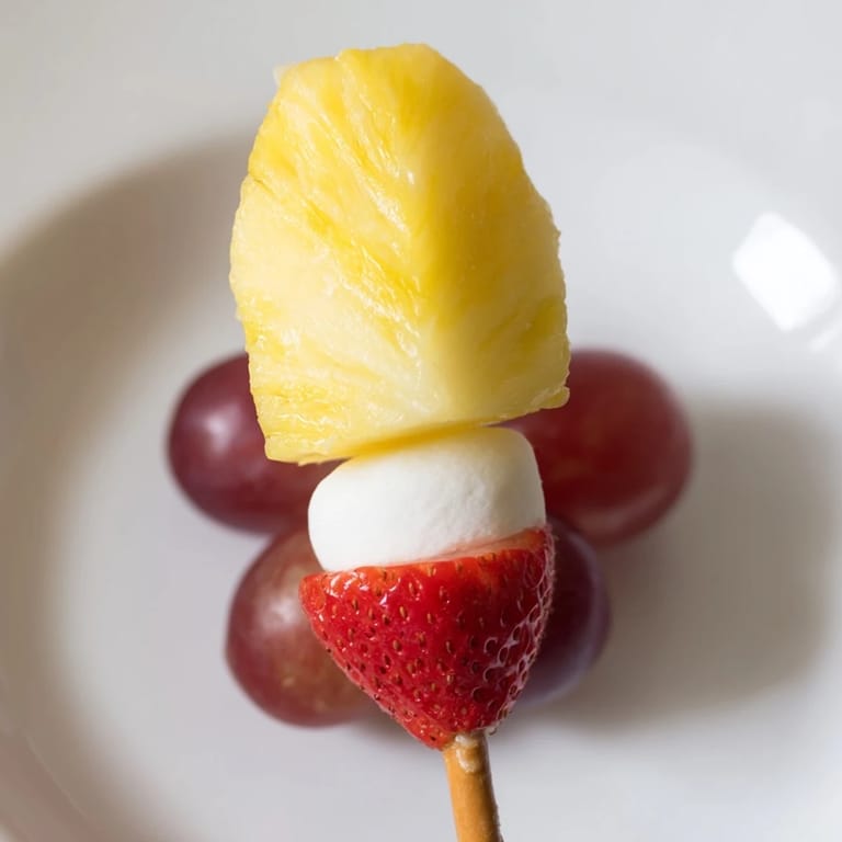 Festive Christmas Light Fruit Skewers feature bright, juicy fruit arranged on pretzel sticks, ready to serve and enjoy.