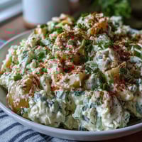 Creamy deviled egg potato salad with tender Yukon Gold potatoes, tangy mustard dressing, and fresh herbs for a perfect picnic side.
